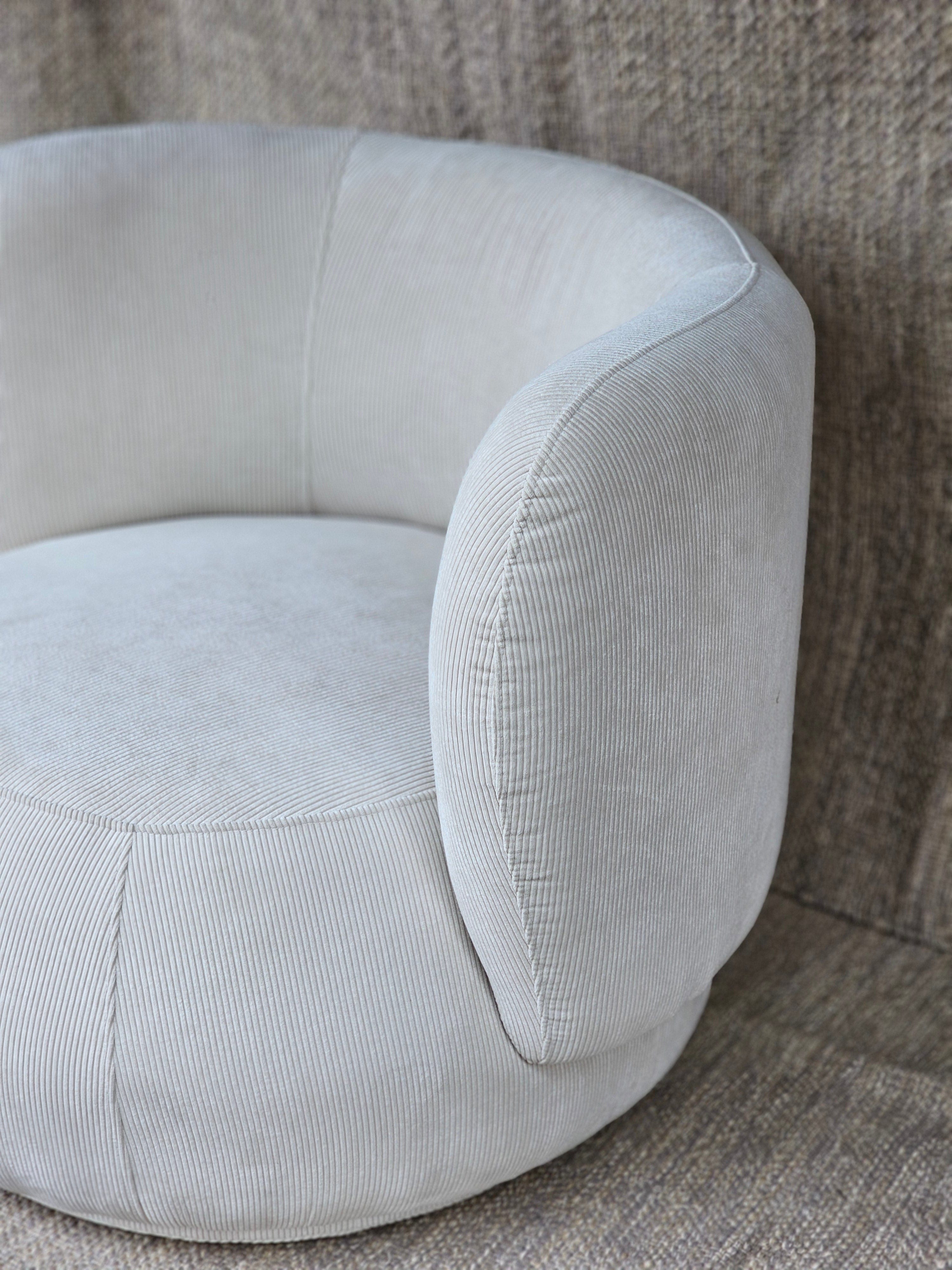 Luna Swivel Armchair with contemporary design and cushioned support, upholstered in light grey ribbed fabric for elegant comfort.