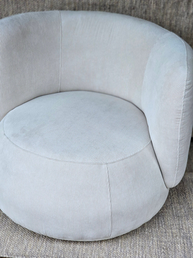Luna Swivel Armchair in soft light grey corduroy fabric with rounded backrest and plush seat, ideal for modern living room seating.