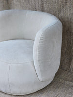 Luna Swivel Armchair with contemporary design and cushioned support, upholstered in light grey ribbed fabric for elegant comfort.