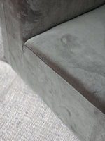 Corner view of the Omega Upholstered Armchair seat with soft grey velvet, highlighting its durable stitching and cozy padding.