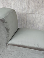 Side profile of the Omega Upholstered Armchair highlighting the seamless stitching and soft grey upholstery for modern interiors.