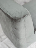 Detail view of the Omega Upholstered Armchair armrest with sleek grey fabric, emphasizing its contemporary style and comfort.