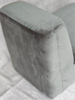 Close-up of the Omega Upholstered Armchair's plush armrest in soft grey velvet, showcasing its smooth texture and modern design.